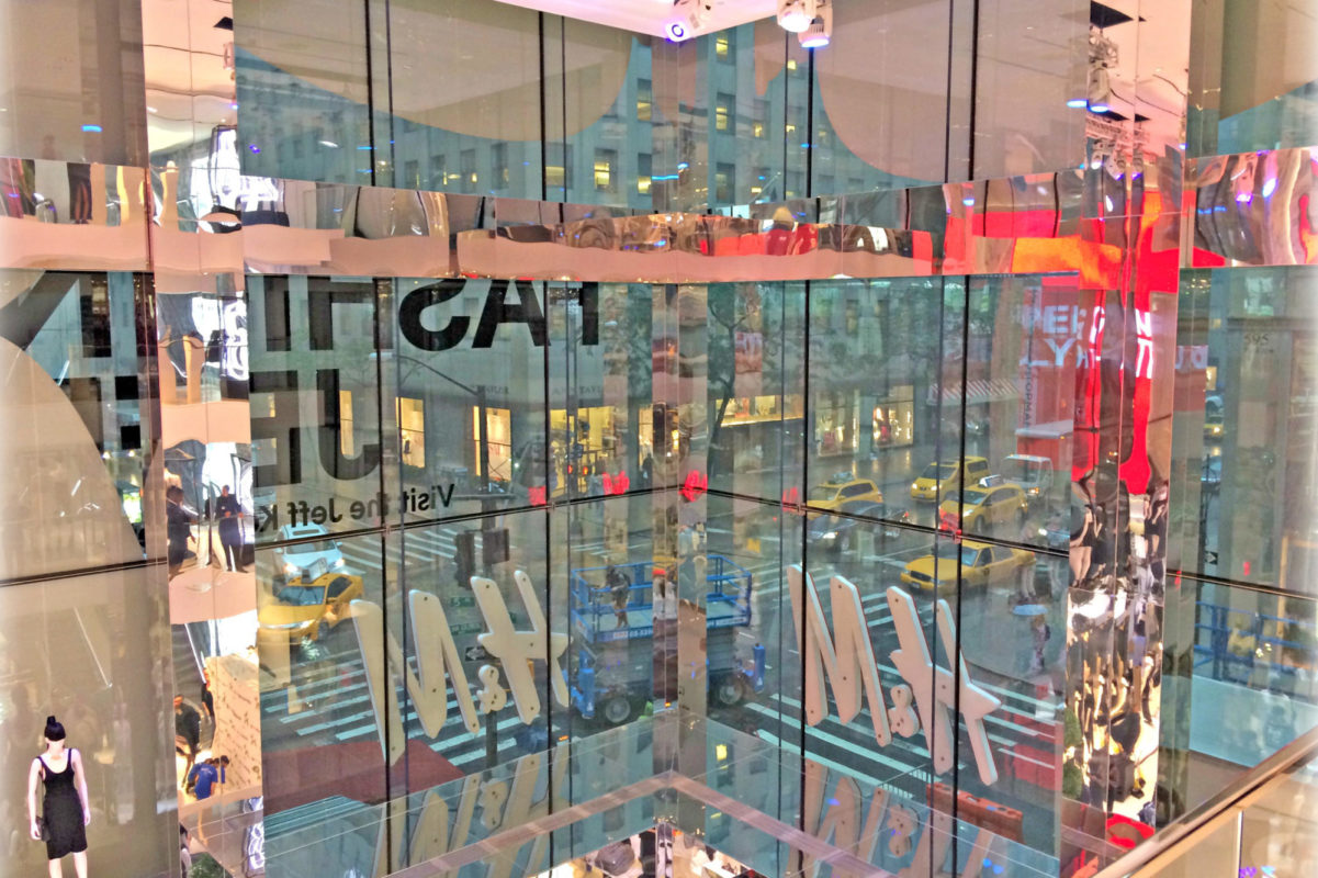 End Product A Seamless All Glass Storefront. Integrated Fittings Inside Of Glass For H&M Signage With Mirror Finish Clad Beams + Columns.
